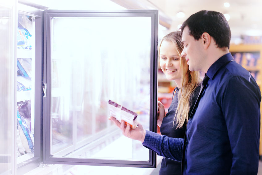 29537914 - couple in the frozen goods section of a grocery store picking out food from the freezer